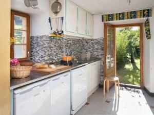 een keuken met witte kasten en een aanrechtblad bij Holiday Home Villa Roduit by Interhome in Le Châble