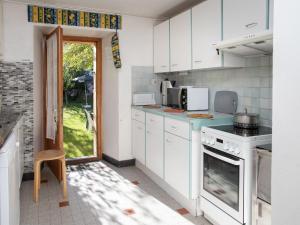 een keuken met witte kasten en een deur naar een tuin bij Holiday Home Villa Roduit by Interhome in Le Châble +38 foto's