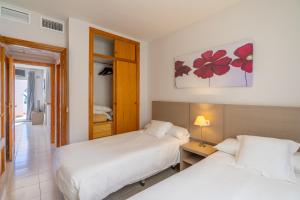 a bedroom with two beds and a table with a lamp at Bungalows Imperial Park Unitursa in Calpe +91 photos