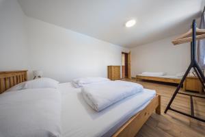 a bedroom with two white beds and a ladder at Chalupa Pod Starú horú in Bohuslavice +19 photos