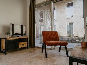 ein Wohnzimmer mit Sessel und Fernseher in der Unterkunft Holiday Home De Zeeparel by Interhome in Egmond aan Zee + 21 Fotos