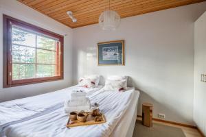 a bedroom with a bed with a tray of baskets on it at Koda Halo Lodge - Sauna, Parking & Playstation in Rovaniemi