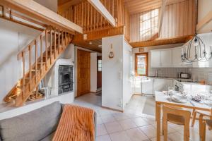 a large kitchen with a staircase and a table at Koda Halo Lodge - Sauna, Parking & Playstation in Rovaniemi