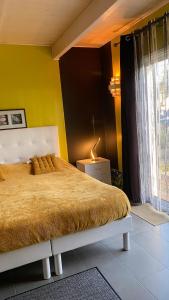 a bedroom with a bed and a yellow wall at Chambre MELUSINE in Néant-sur-Yvel +5 photos