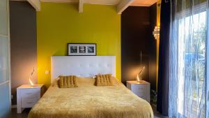 a bedroom with a large bed with a yellow wall at Chambre MELUSINE in Néant-sur-Yvel