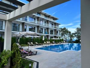 a hotel with a swimming pool with chairs and umbrellas at Double studio Petra B2-5 in Byala