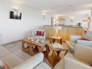 a living room with a couch and a table at Apartment Les Aiguilles Vertes Rez inférieur by Interhome in Crans-Montana
