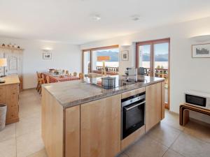 een keuken met aanrechtblad en een woonkamer bij Apartment Les Aiguilles Vertes Rez inférieur by Interhome in Crans-Montana