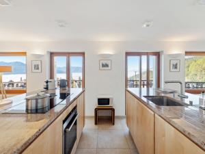 a kitchen with a large counter top and windows at Apartment Les Aiguilles Vertes Rez inférieur by Interhome in Crans-Montana
