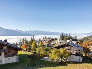 a view of a village with mountains in the background at Apartment Les Aiguilles Vertes Rez inférieur by Interhome in Crans-Montana