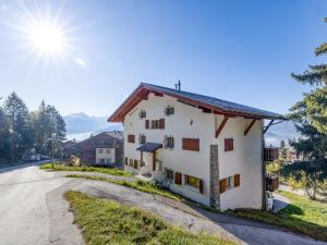 a white house with the sun in the sky at Apartment Les Aiguilles Vertes Rez inférieur by Interhome in Crans-Montana