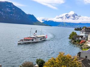 um barco num lago com montanhas ao fundo em Apartment Apartment 10 by Interhome em Weggis