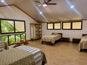 a room with two beds and a ceiling fan at Los Vivos Beachfront Experience in Pochote +57 photos