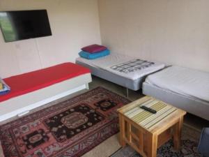 a room with two beds and a coffee table at One Large Room with 3 single beds in Gothenburg