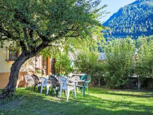Eine Gruppe von Stühlen und Tischen unter einem Baum in der Unterkunft Holiday Home Villa Roduit by Interhome in Le Châble