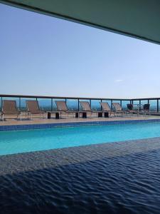 a row of chairs sitting next to a swimming pool at Promenade Prime Itaboraí in Itaboraí