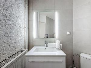 a white bathroom with a sink and a mirror at Apartment Le Curling B - Val Claret-30 by Interhome in Tignes