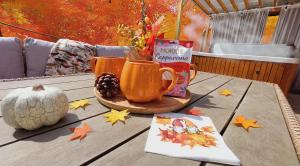ein Holztisch mit zwei Tassen und einer Schachtel darauf in der Unterkunft Chillinn Bikavér Cottage Eger in Eger