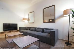 a living room with a couch and a flat screen tv at Brera Apartments in Duomo in Milan