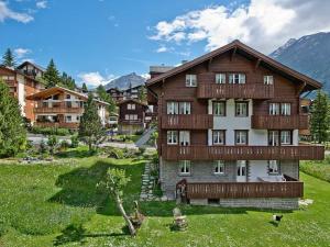 een groot houten huis in een grasveld bij Apartment Maria by Interhome in Saas-Fee