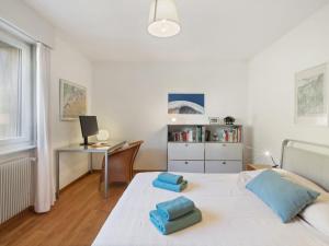 a bedroom with a white bed with blue towels on it at Apartment Belmont Est 80 by Interhome in Vermala