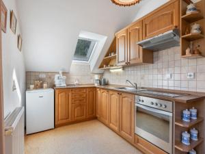 a kitchen with wooden cabinets and a white appliance at Holiday Home Kralovice by Interhome in Nebahovy