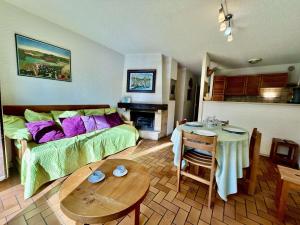 ein Zimmer mit einem Bett und einem Tisch und einer Küche in der Unterkunft Charmant T2 avec coin montagne, 6 couchages, Monêtier les Bains, proche commerces et navettes ski - FR-1-330F-35 in Le Monêtier-les-Bains