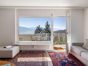uma sala de estar com um sofá e uma janela grande em Apartment Clair-Azur A 41 by Interhome em Crans-Montana mais 31 fotografias