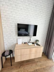 a flat screen tv on a white brick wall at Double studio Petra B2-5 in Byala