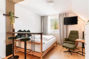 a bedroom with a bed and two chairs and a television at Hike & Ski-in Ski-out Mountain View Apartment for Family & Friends in Hinterstoder