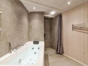 a bathroom with a white tub and a shower at Holiday Home Franke - 1-1km from the sea by Interhome in Hjørring