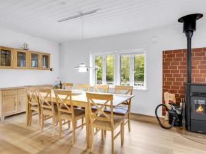 Un comedor con mesa y sillas y chimenea. en Holiday Home Siiri - 28km from the sea by Interhome, en Toftlund