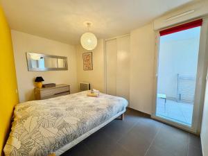 a bedroom with a bed and a large window at Appartement centrale à 100 m des plages Rue de Provence in Saint-Raphaël