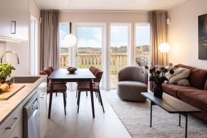 uma cozinha e sala de estar com um sofá e uma mesa em Skerike Golfhus em Västerås