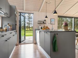 een keuken met witte kasten en een groot eiland bij Holiday Home Talitha - 1-5km from the sea by Interhome in Hjørring