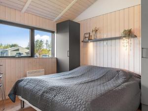 een slaapkamer met een bed en een groot raam bij Holiday Home Talitha - 1-5km from the sea by Interhome in Hjørring