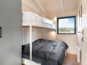 een slaapkamer met een stapelbed in een tiny house bij Holiday Home Talitha - 1-5km from the sea by Interhome in Hjørring +18 foto's