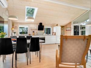 a kitchen with a table and black chairs at Holiday Home Delco - 200m from the sea by Interhome in Hals