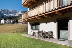 een patio met een tafel en stoelen aan de zijkant van een huis bij Cesa Pattis in Campestrin