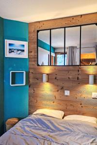 a bedroom with a large bed with a wooden wall at Apartment Nazca I6 by Interhome in Val Thorens