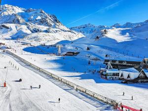 a group of people skiing down a snow covered mountain at Apartment Nazca I6 by Interhome in Val Thorens