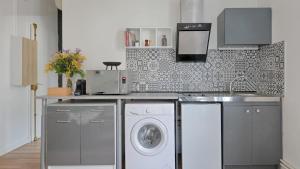 una cucina con lavatrice e lavandino di Flower's Power a Vitry-sur-Seine