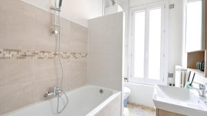 un bagno bianco con vasca e lavandino di Flower's Power a Vitry-sur-Seine