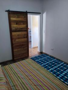 ein Schlafzimmer mit einer Holztür und einem Teppich in der Unterkunft Lo de Tina II in Florencio Varela + 9 Fotos