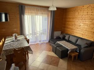 una sala de estar con un sofá y una mesa en Domki Urbaczka w Istebnej, en Istebna