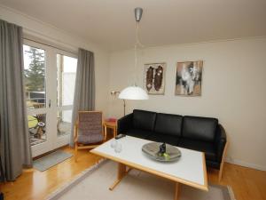 a living room with a black couch and a table at Apartment Runhild - 100m from the sea by Interhome in Hals
