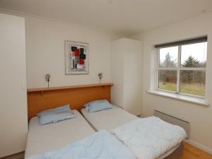 two beds in a room with two windows at Apartment Runhild - 100m from the sea by Interhome in Hals