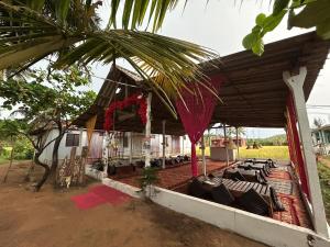 un groupe de chaises sous le toit d'une maison dans l'établissement Sukhi Beach Cottage, à Gokarna