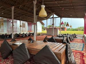 Cette grande chambre dispose d'une grande table et de chaises en bois. dans l'établissement Sukhi Beach Cottage, à Gokarna