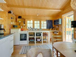 a kitchen with wooden walls and a wooden ceiling at Holiday Home Ascen - 300m from the sea by Interhome in Læsø